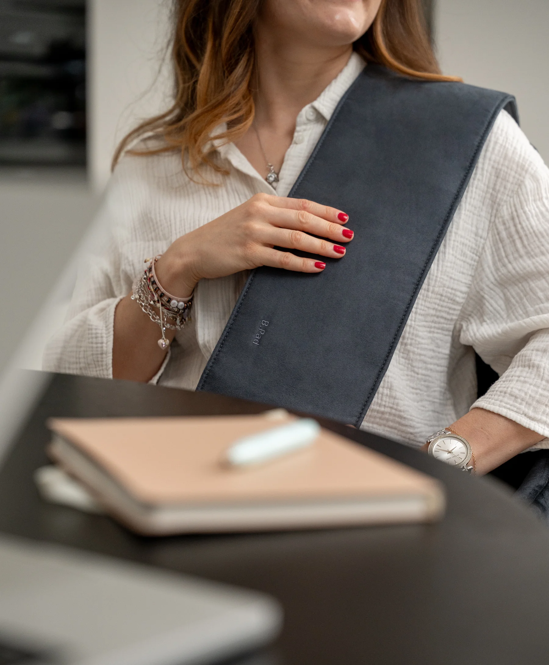 Frau nutzt BEMER B.Spot Applikator am Schreibtisch im Homeoffice
